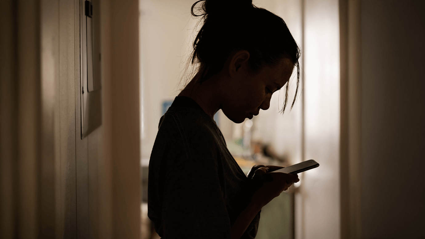 Silhouette of woman looking at phone.