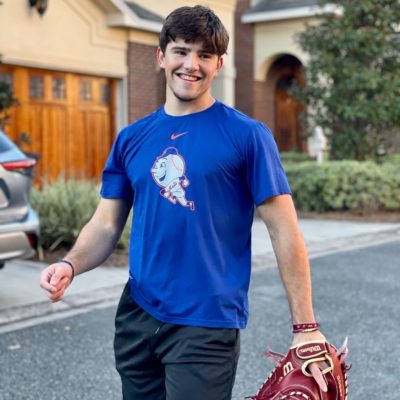 young man smiling wearing baseball mit