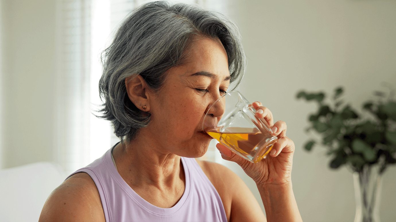 Woman drinks a glass of juice.
