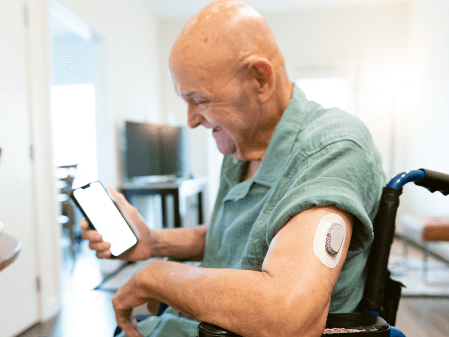 Man wearing CGM checks his phone.