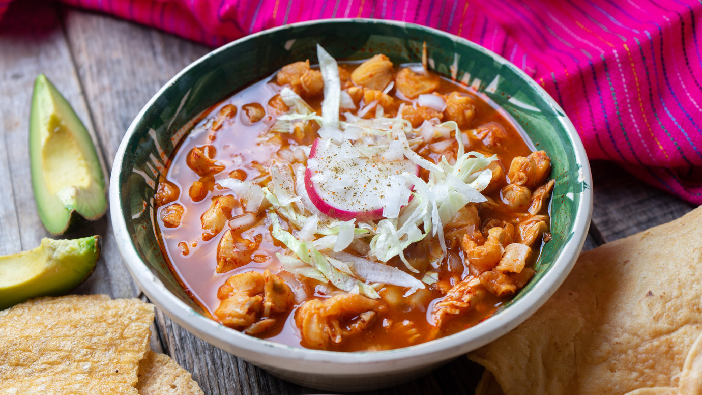 Hearty bowl of posole with a garnish.