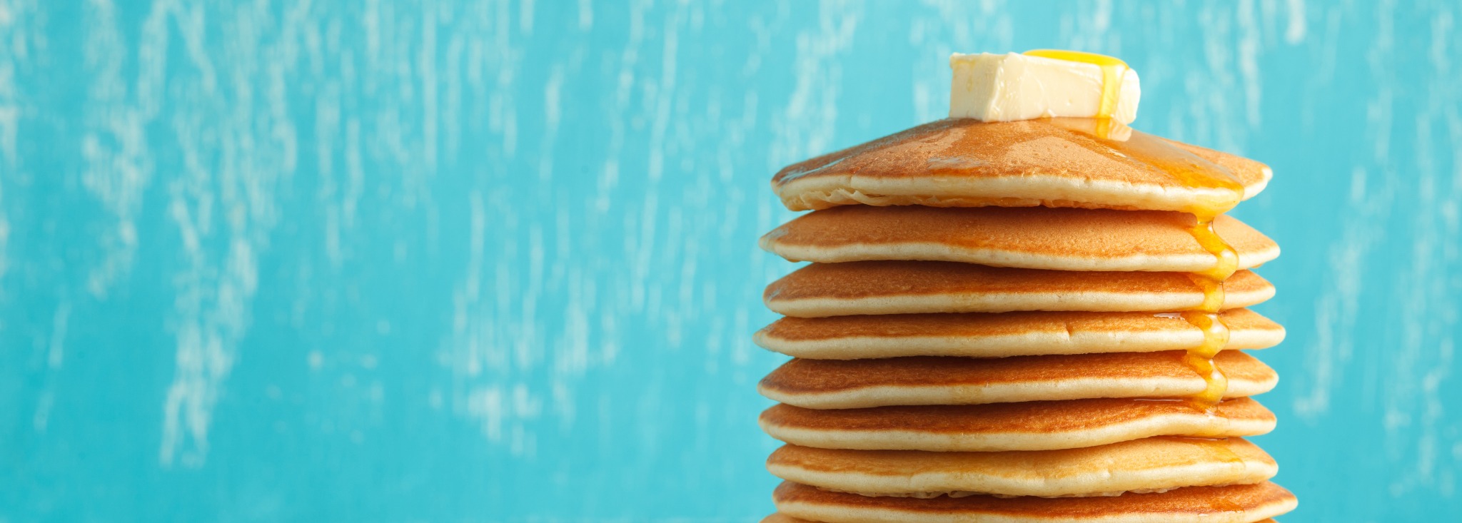 A high stack of low-sugar pancakes topped with butter.