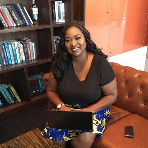 Quisha Umemba, MPH, BSN, RN, CDCES, CHWI, smiles while working on a laptop.