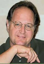 Country music songwriter, Steve Seskin, wears glasses and smiles.