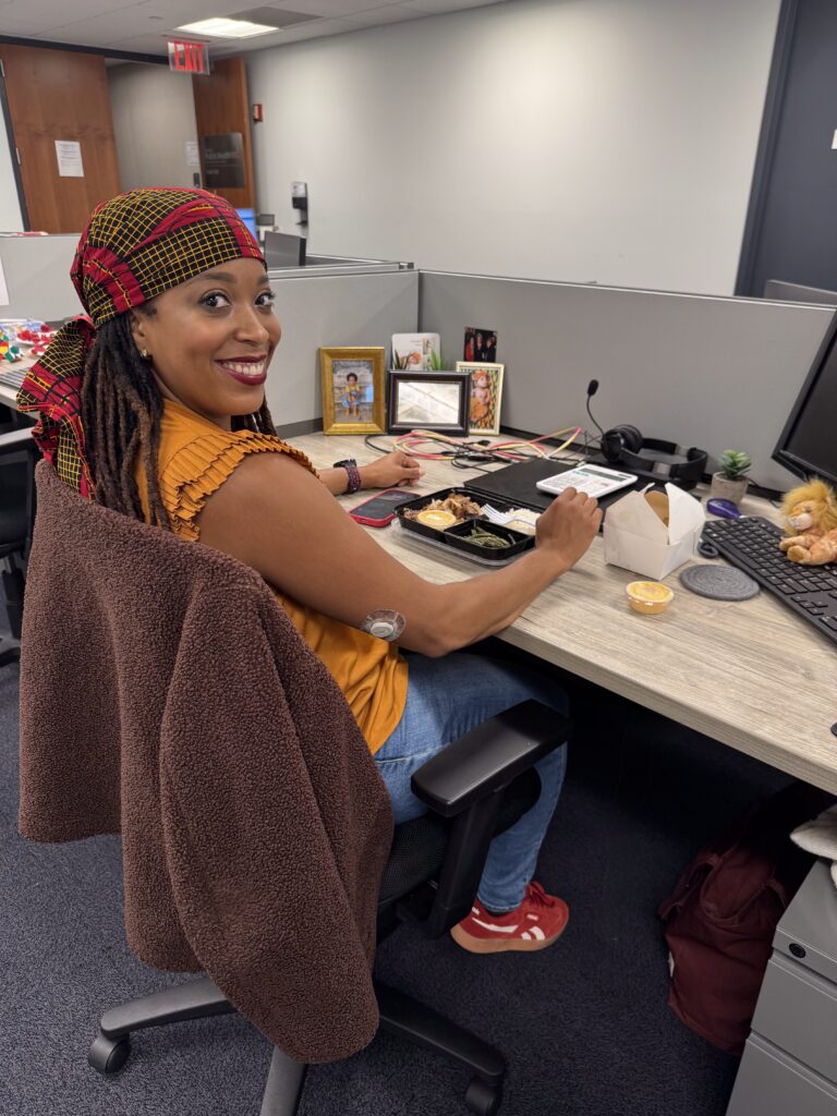 Ariel has a bite of food at desk.