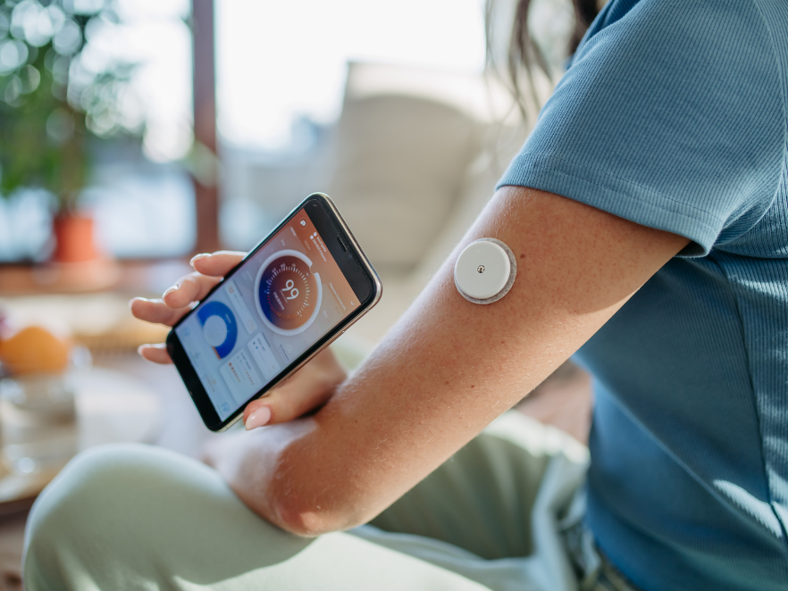 Woman wearing CGM and checking mobile app