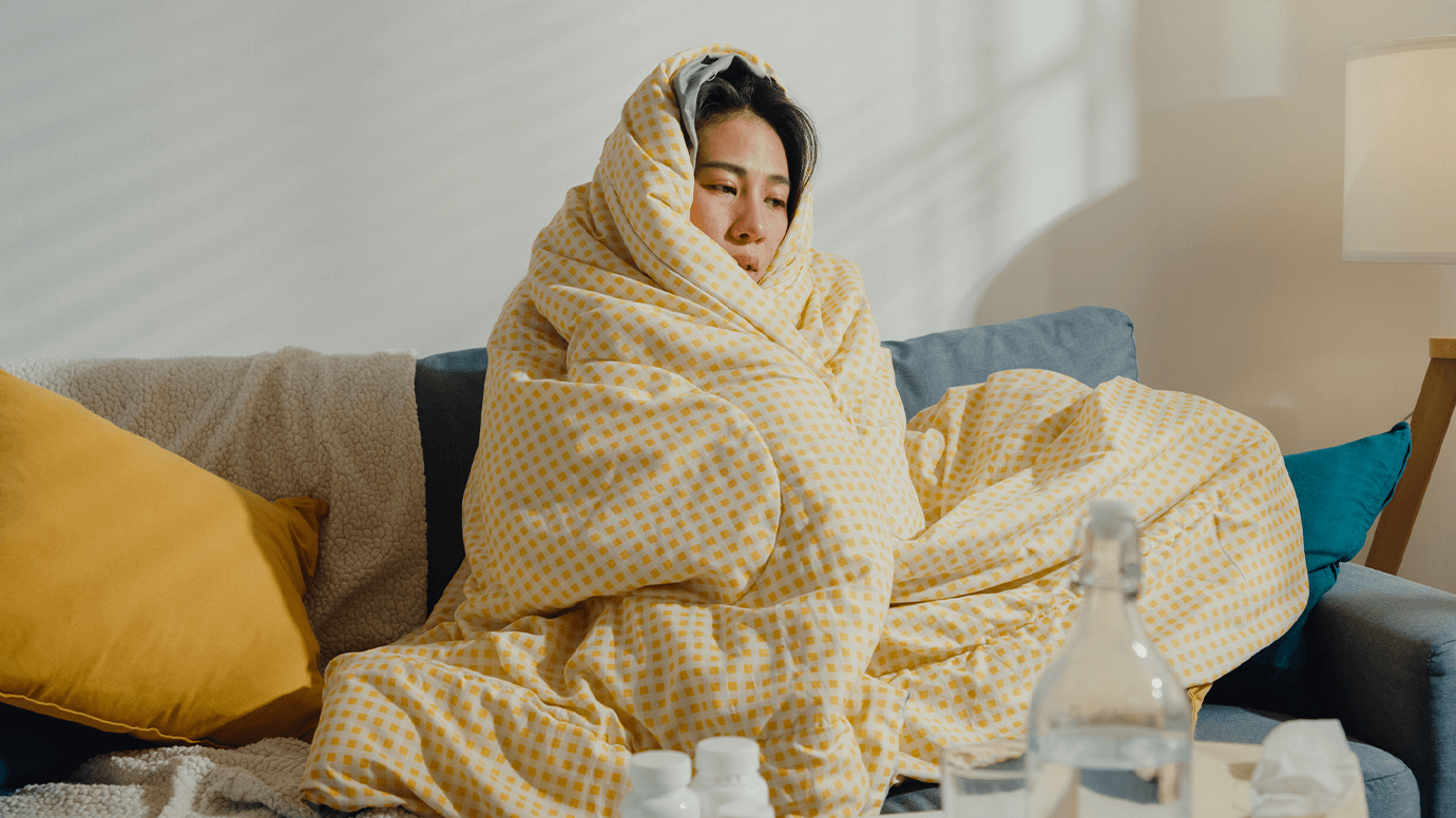 Sick girls snuggles up in blanket.