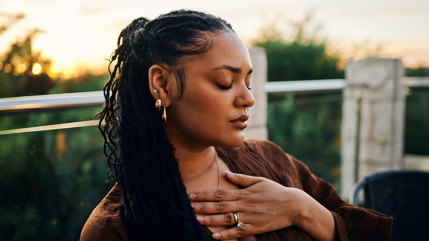 Woman holds hand over her chest.